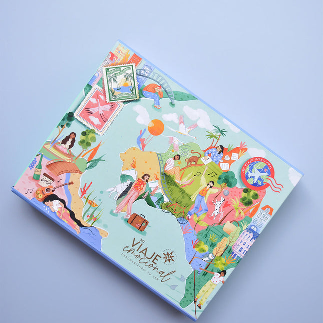 Caja Kit Mi Viaje Emocional Amuratta con itinerario, tarjetas, pasaporte y postal ilustrada para gestionar emociones.