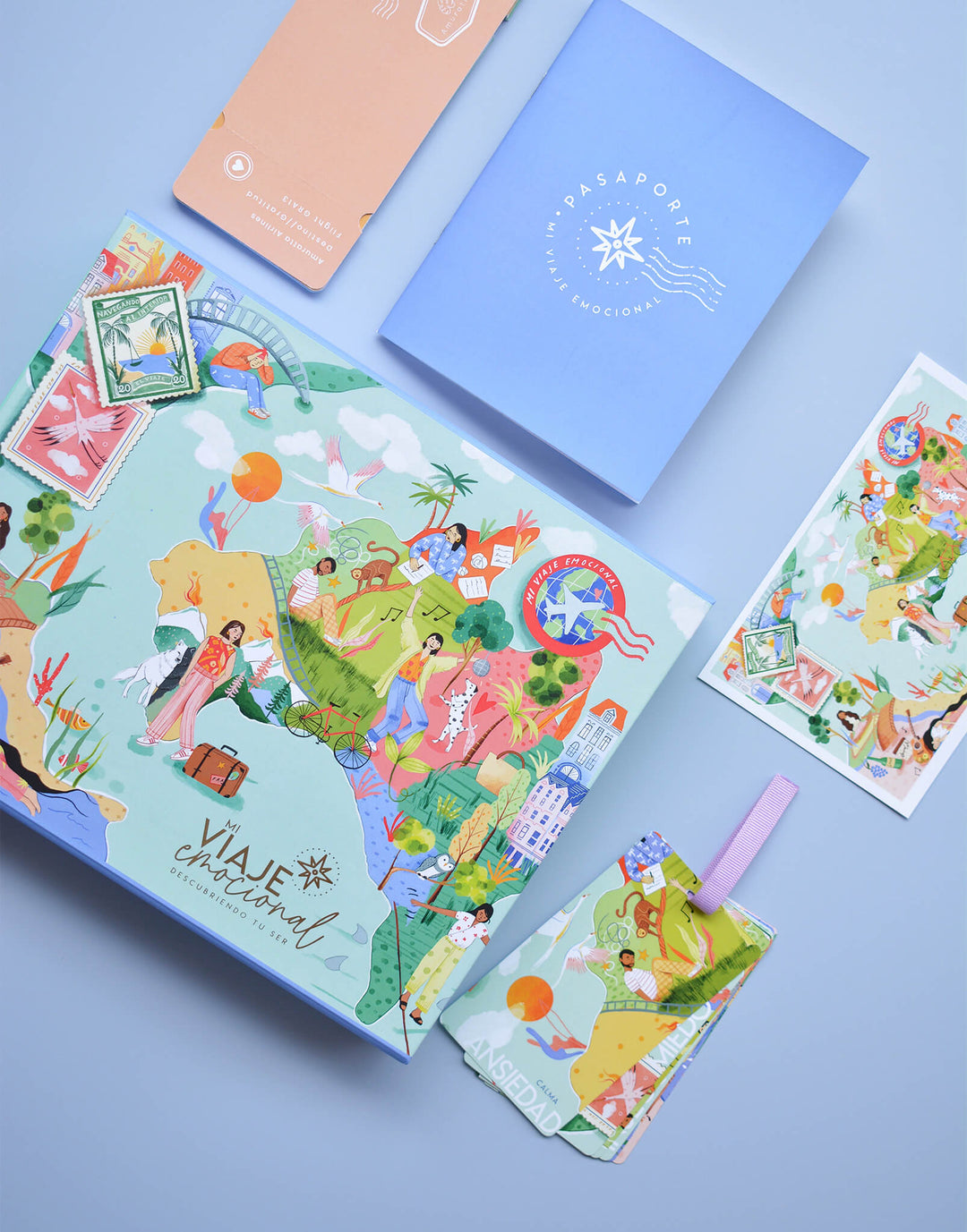 elementos Caja Kit Mi Viaje Emocional Amuratta con itinerario, tarjetas, pasaporte y postal ilustrada para gestionar emociones.