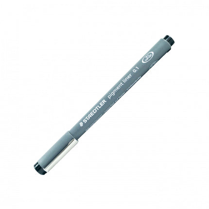 Rapidógrafo Staedtler negro 0.1 mm con punta metálica fina, cuerpo gris y capuchón, sobre papel de dibujo técnico.

