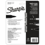 Ocho marcadores Sharpie de punta fina con barril gris y tapas de colores variados, alineados sobre fondo blanco.

