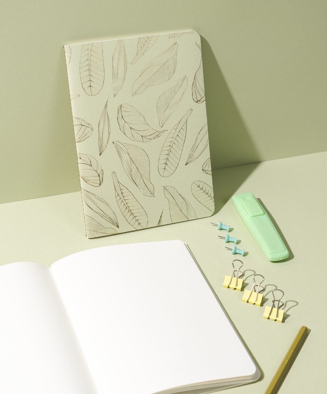 Libreta Econotas Alpen 15×21 cm verde con estampado de hojas en foil dorado y 32 hojas ecológicas cosidas en hilo.