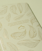 Detalle posterior Libreta Econotas Alpen 15×21 cm verde con estampado de hojas en foil dorado y 32 hojas ecológicas cosidas en hilo.