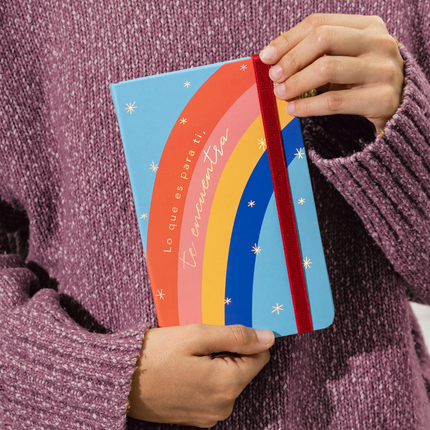 Sketchbook Alpen 12×20 cm tapa dura con diseño arcoíris y frase “Lo que es para ti, te encuentra”, banda elástica roja y 84 hojas blancas.