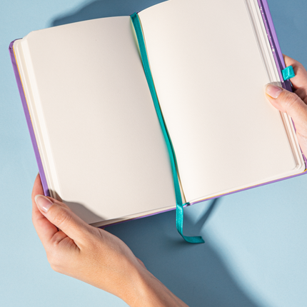 Hojas Sketchbook Alpen 12×20 cm morado con tapa dura ilustrada “Lánzate al universo”, banda elástica turquesa y 84 hojas blancas.