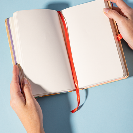 Páginas Sketchbook Alpen 12×20 cm con tapa dura floral y frase “Amo todo lo que soy”, banda elástica morada y 84 hojas blancas.