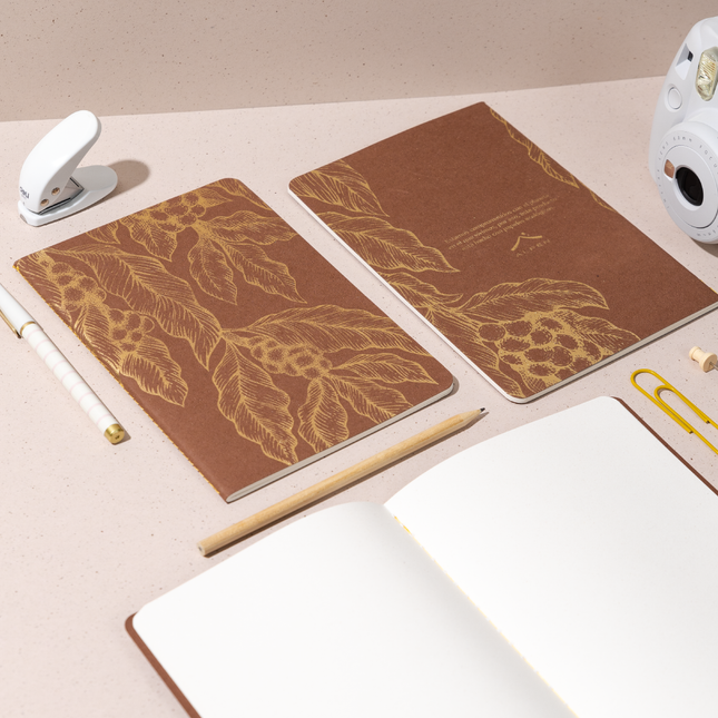 Libreta Econotas Alpen 15×21 cm color café con ilustraciones de ramas en foil cobre y 32 hojas ecológicas cosidas en hilo.