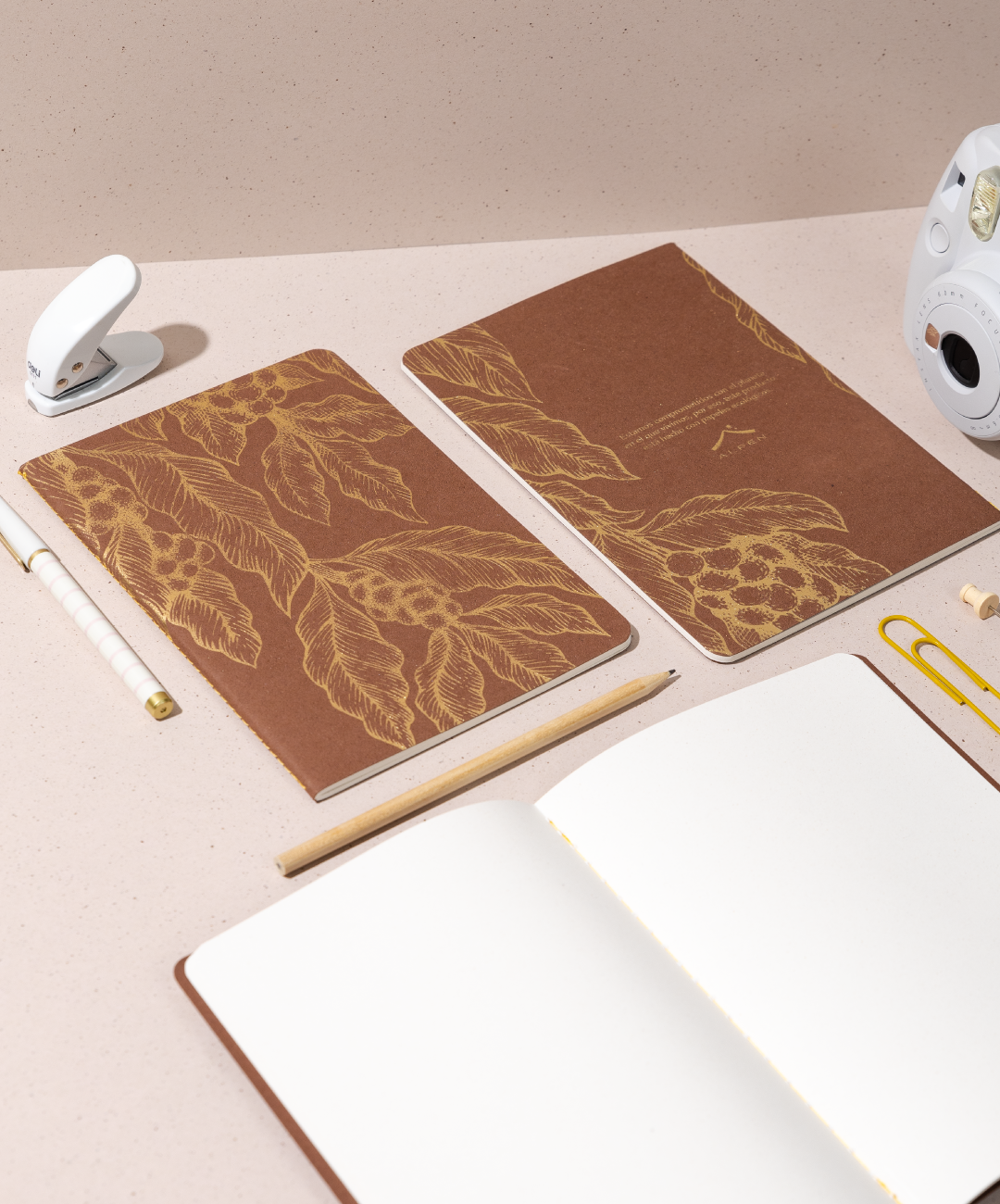 Libreta Econotas Alpen 15×21 cm color café con ilustraciones de ramas en foil cobre y 32 hojas ecológicas cosidas en hilo.