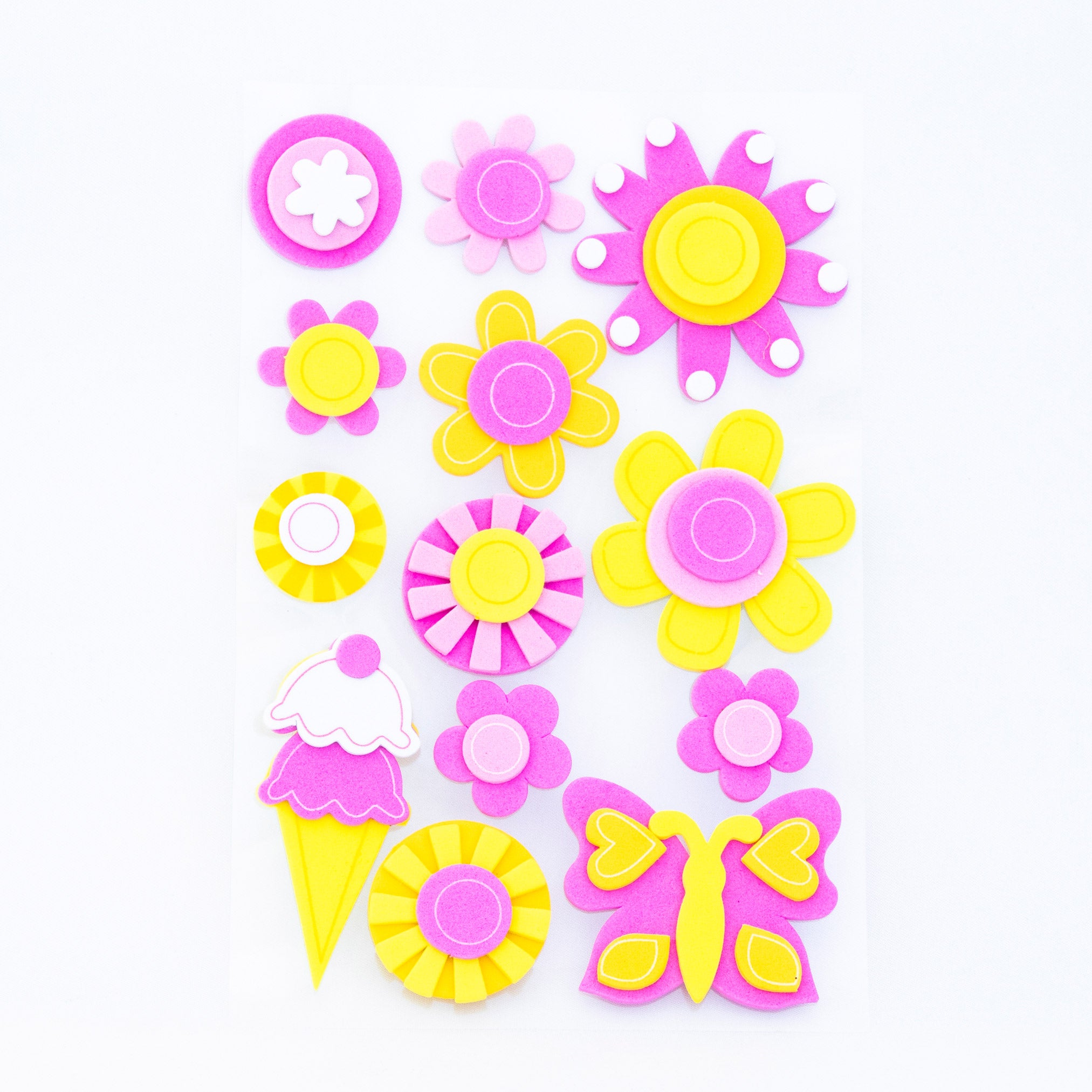 Figuras adhesivas de foamy Evacolor con diseños de flores, mariposas y helado en colores rosa y amarillo para manualidades escolares y creativas.